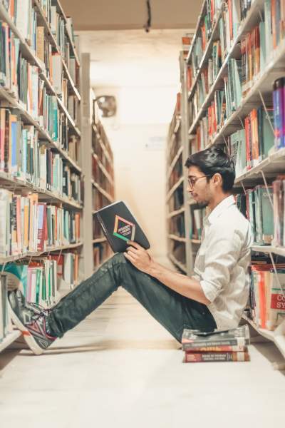 alt="student reading in library"